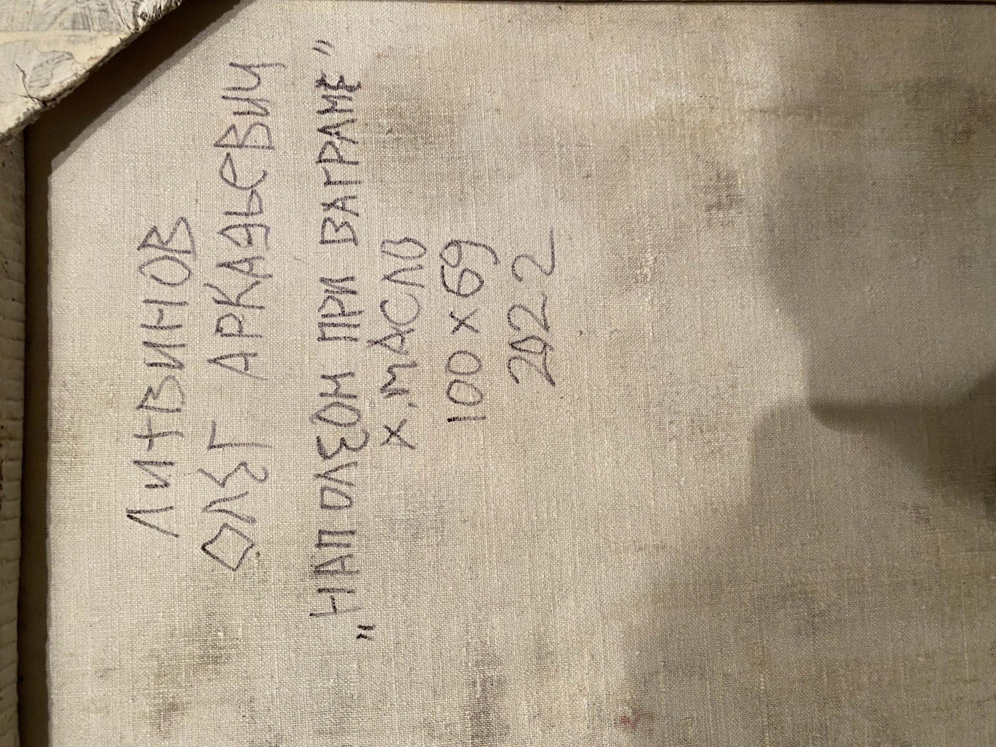 Handwritten inscription on a textured, off-white fabric surface.