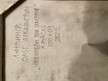 Handwritten inscription on a textured, off-white fabric surface.