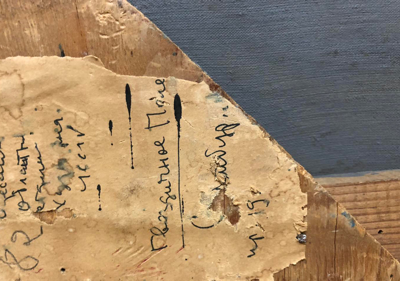 Back of oil painting Flower field by Sambur Arkady Gesejonovich with torn beige paper Cyrillic script and ink stains