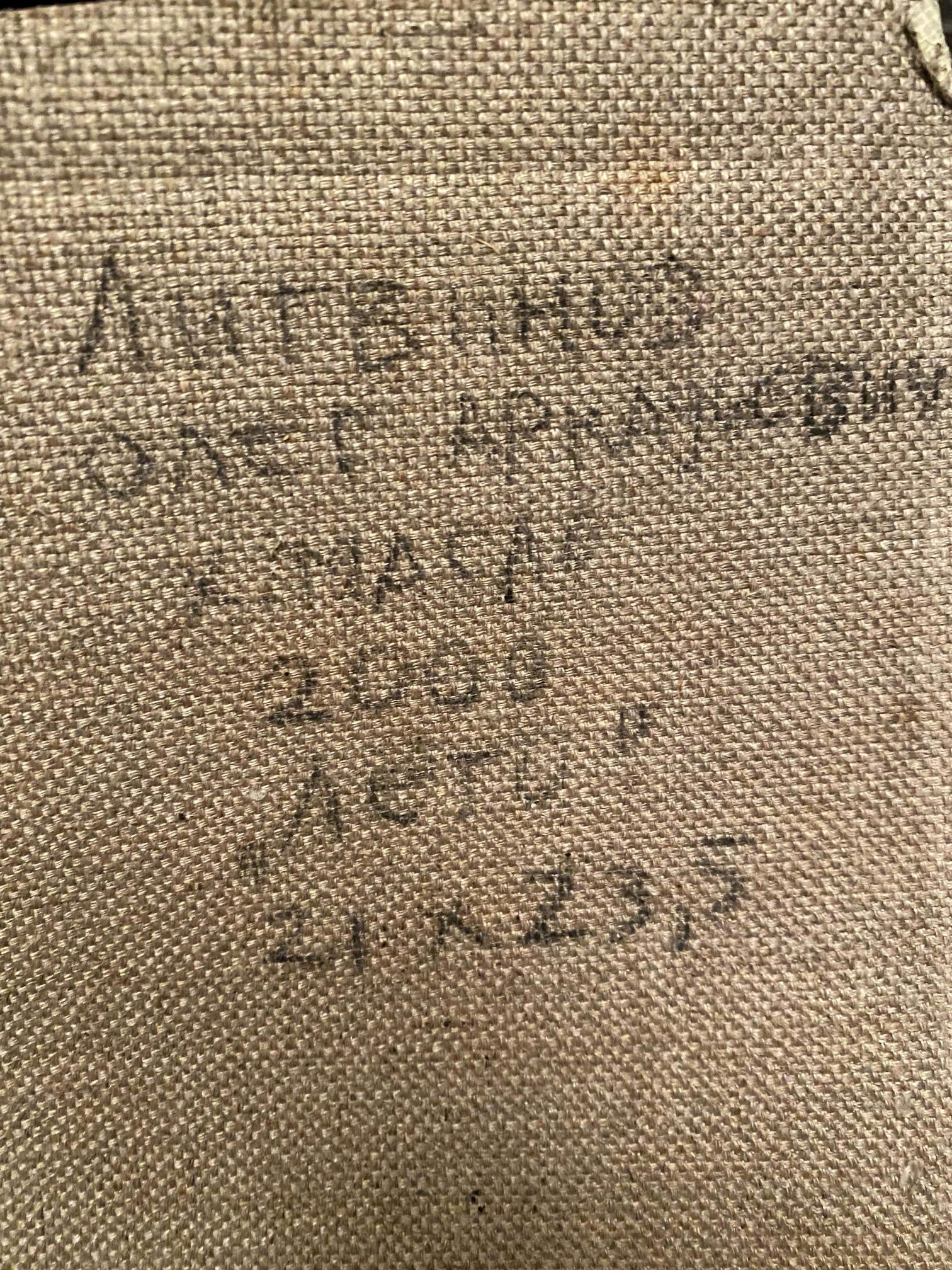 Back of Oleg Litvinov oil painting on beige woven fabric with faded Cyrillic text