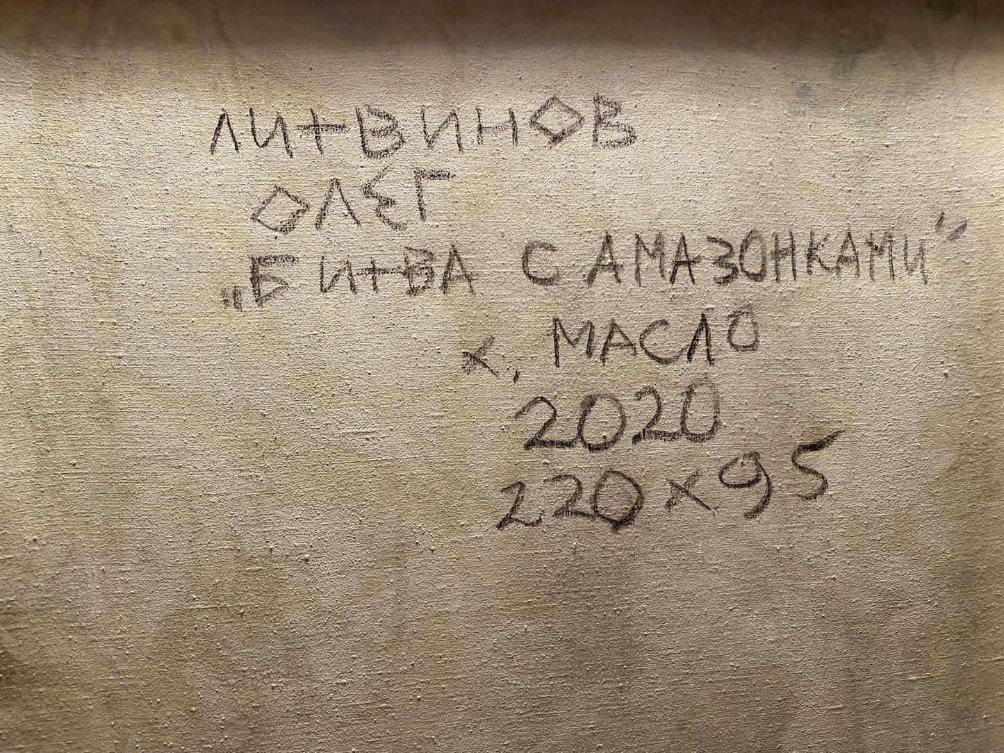 Back of beige canvas oil painting Battle with the Amazons by Litvinov Oleg Arkad’yevich with black handwritten artist title medium year dimensions inscription