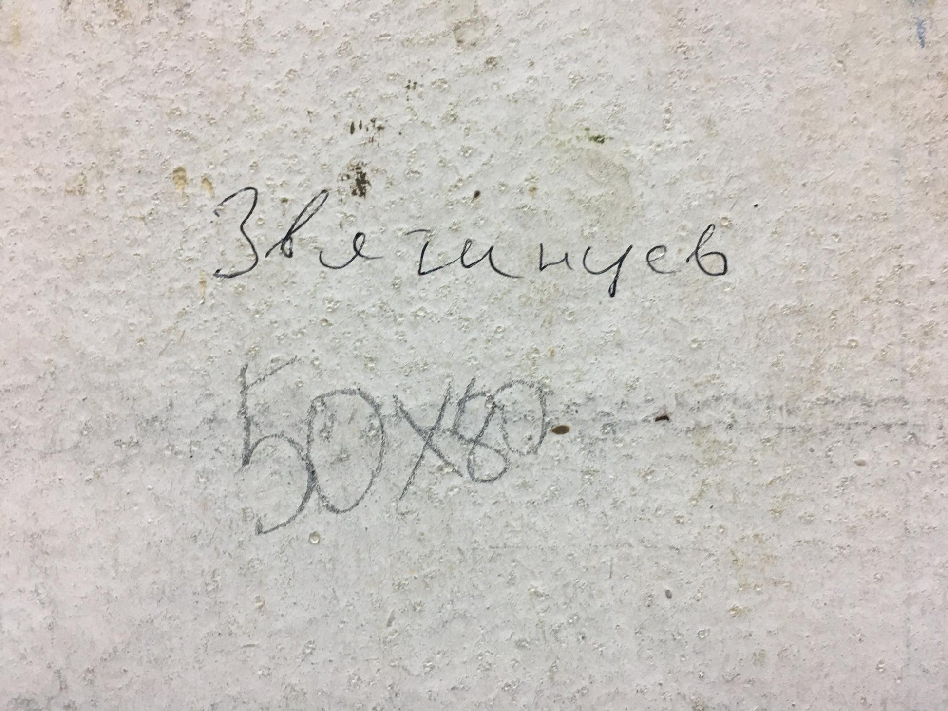 Handwritten cyrillic text and numerical measurements on a textured, light-colored concrete surface.
