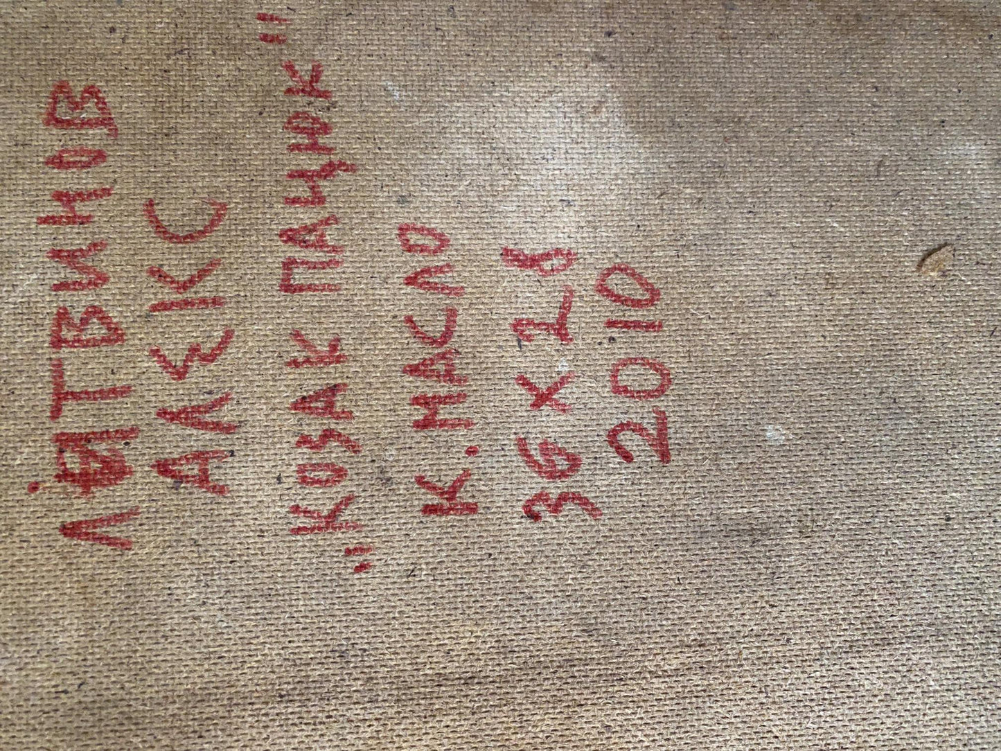 Red handwritten Cyrillic text on beige fabric back of Kozak Patsyuk painting