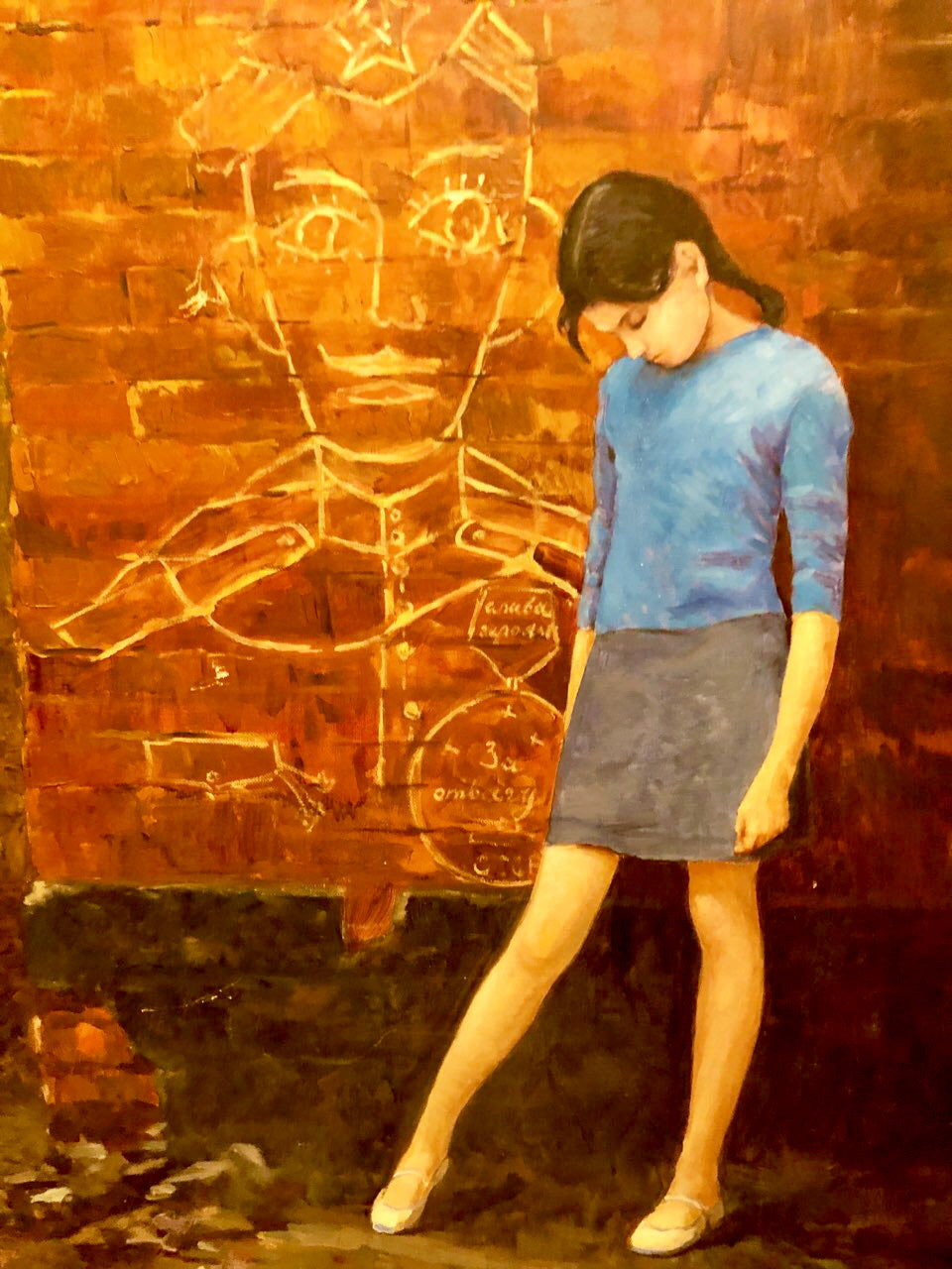 Oil painting by Dad Labinok Leonid: young woman in blue top, gray skirt before orange brick wall with chalk drawings