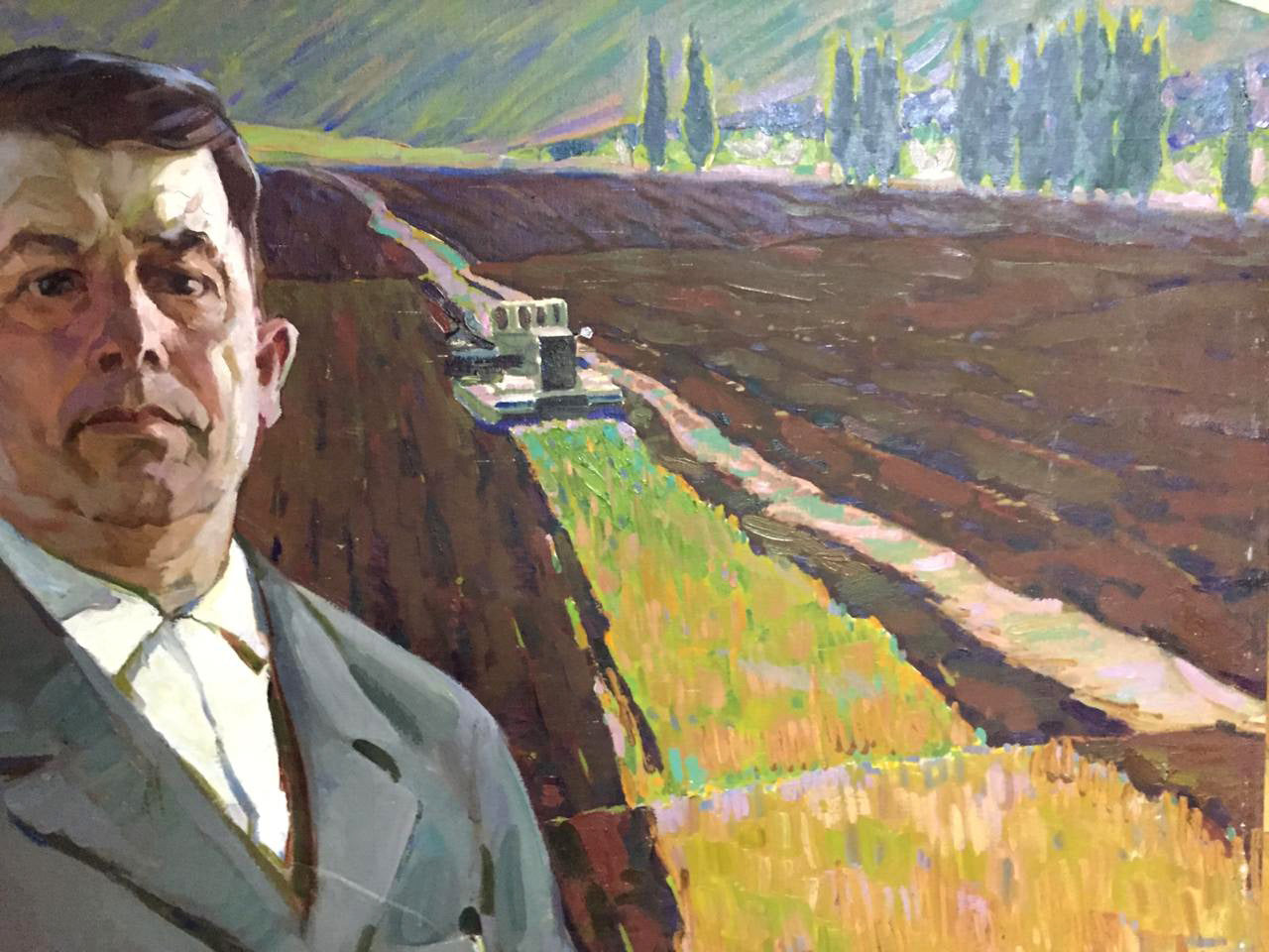 Social realism oil painting by Chvala Dmitry Andreevich: man in gray suit before tractor field