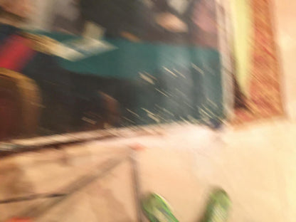 Oil painting Graduation: blurry green shoe with textured upper on light floor