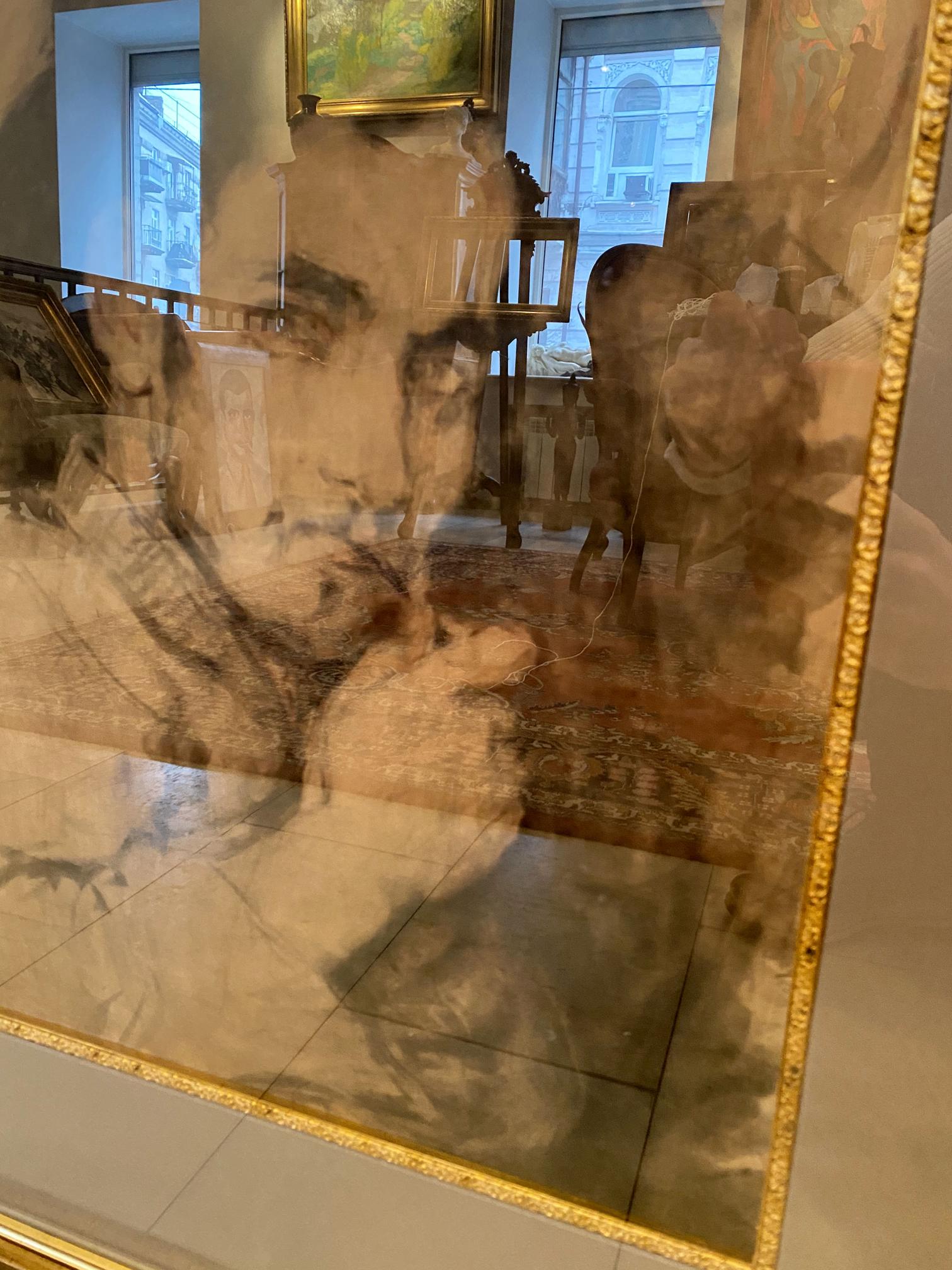Gold-framed Repin portrait mirror with distorted room reflections